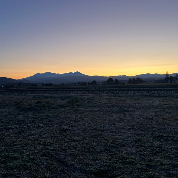 北海道東川町から見た大雪山の夕景。金色に染まる空と山々のシルエット。